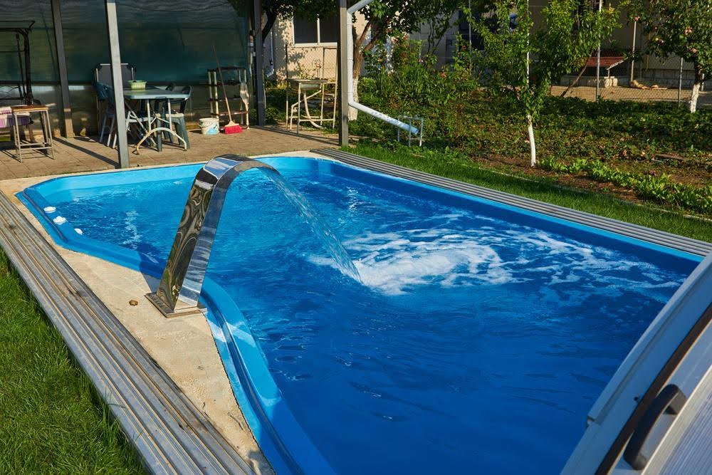 water fountain - Van Kirk & Sons Pools & Spas A residential pool with swimming pool accessories inside.