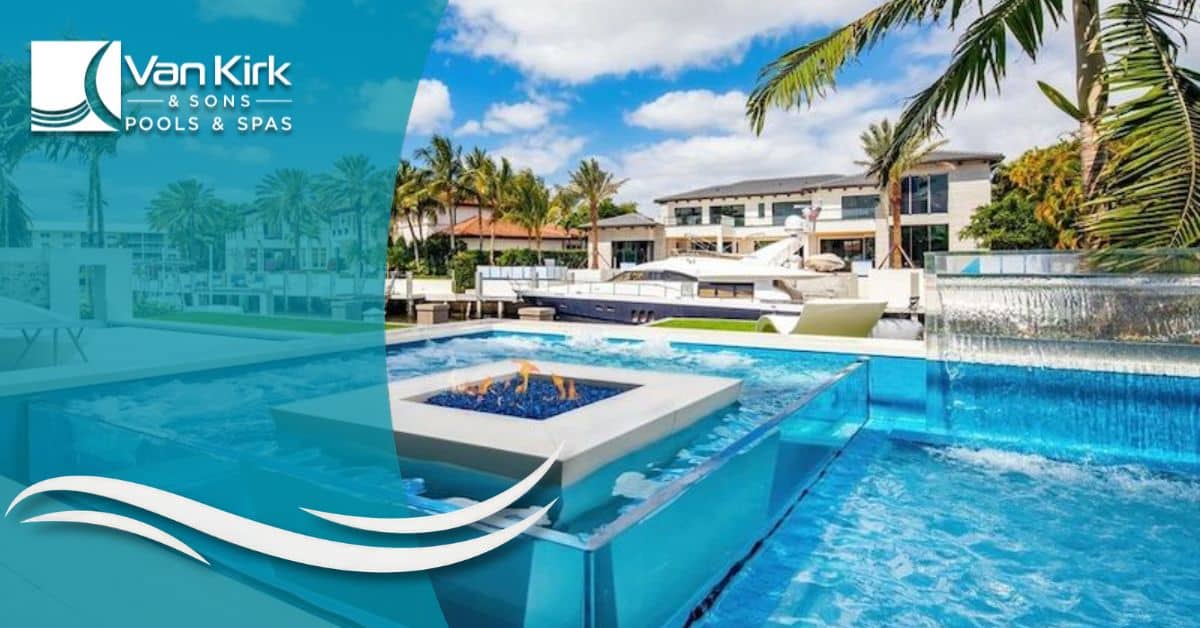 Modern luxury glass-edge swimming pool with fire feature overlooking waterfront homes by Van Kirk Pools