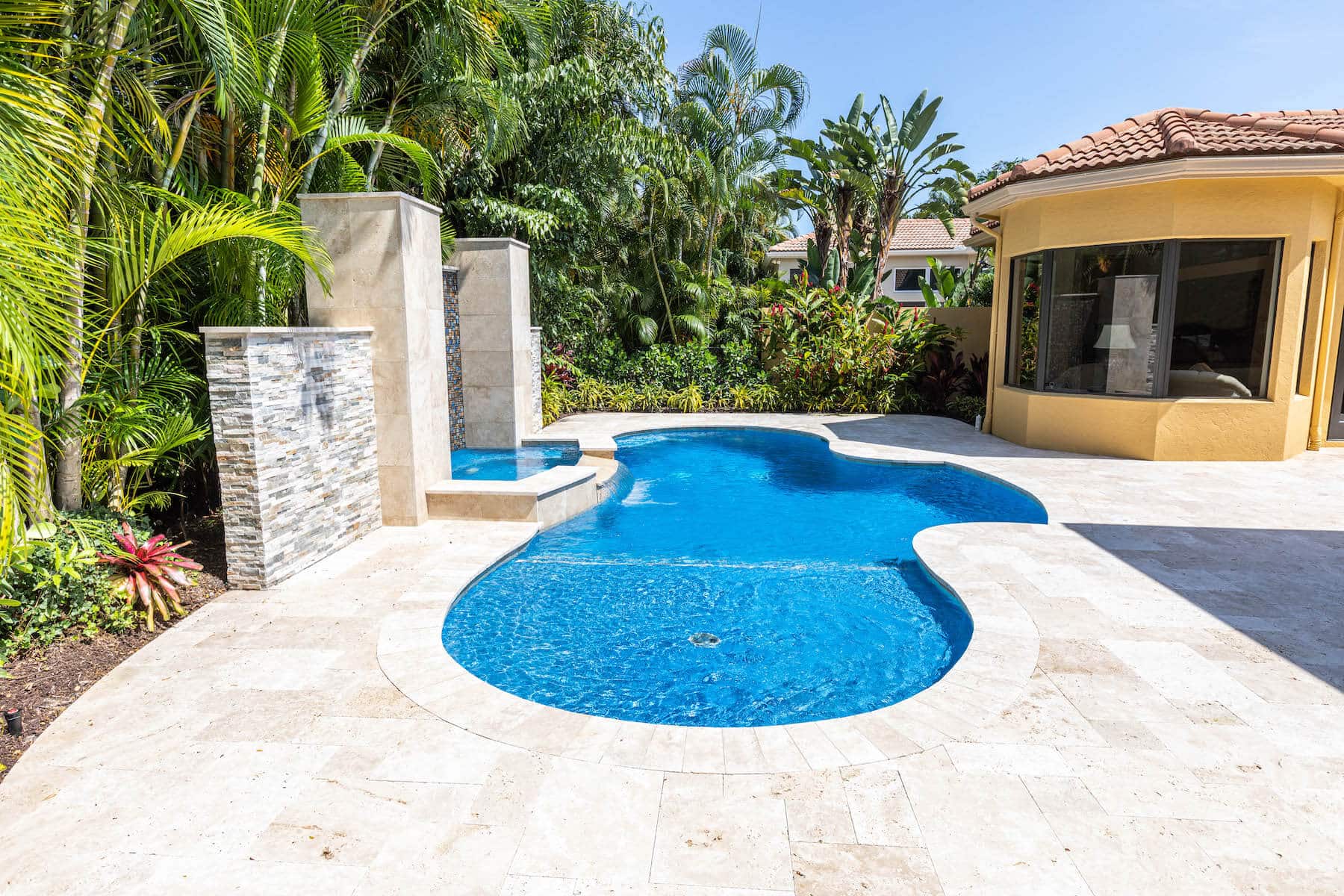 A Florida hot tub waterfall going into a pool - Van Kirk & Sons Pools & Spas A Florida hot tub waterfall going into a pool