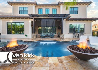Luxury backyard with pergola, pool, fire bowls, and seating area, showcasing Van Kirk & Sons Pools & Spas design.