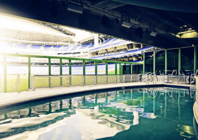 Luxurious swimming pool with a view of a modern sports stadium seating area.