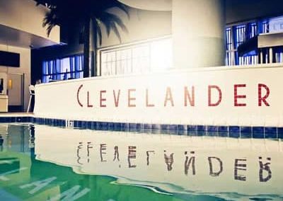 Poolside view at The Clevelander hotel with signage reflection, modern interior, and palm tree decor.