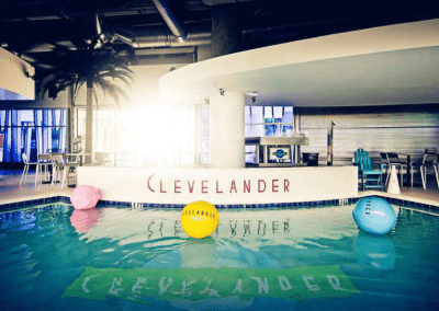 Clevelander indoor pool with colorful beach balls and palm tree, evoking a tropical resort vibe.