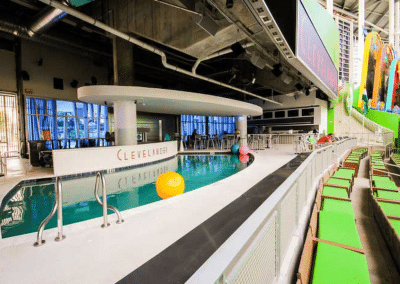 Indoor pool area with colorful beach balls, seating, and bar at a modern venue, perfect for events and relaxation.