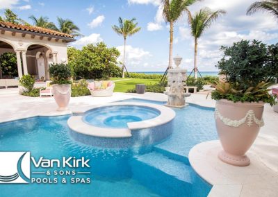 Luxury pool and spa with ocean view, tropical plants, custom pool tiles, and elegant patio design by Van Kirk & Sons Pools & Spas.