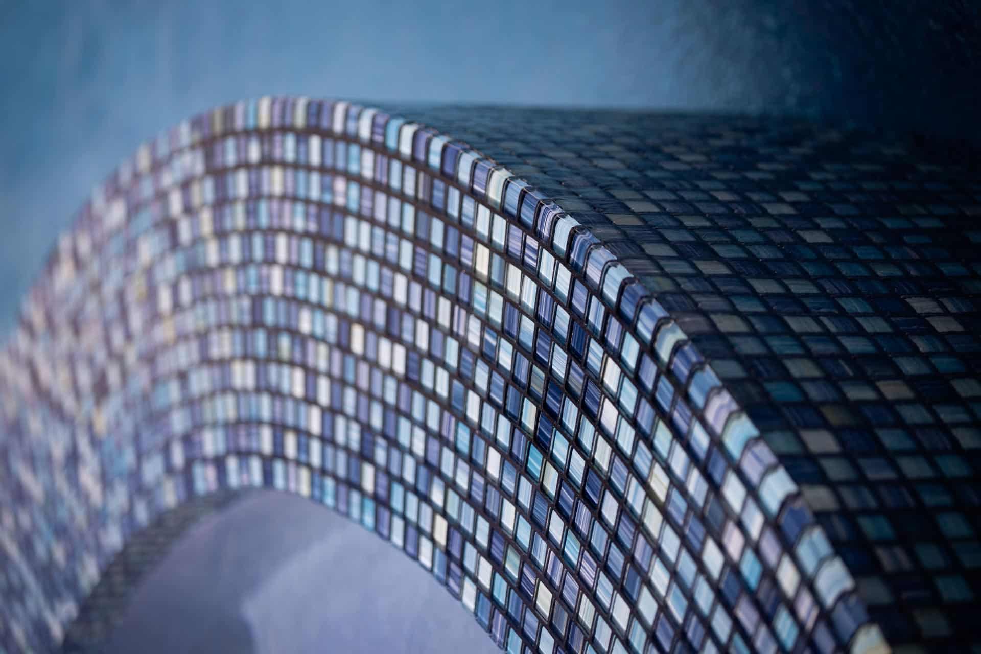 Curved blue and white custom mosaic pool tile detail in modern architecture.