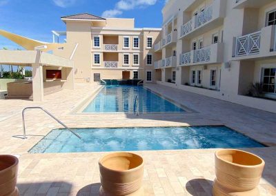 Luxury hotel with a pool, sunny courtyard, and modern architecture; perfect for a relaxing vacation retreat.