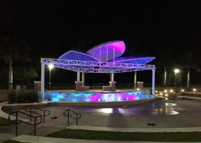 Lit pavilion at night with colorful LED lights, modern architecture, and peaceful ambiance for outdoor events.