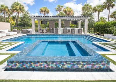 Luxurious backyard with modern swimming pool, hot tub, and stylish outdoor seating under a pergola.