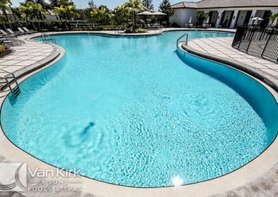 Luxurious backyard swimming pool with crystal-clear water and a tiled deck, designed by Van Kirk & Sons Pools & Spas.