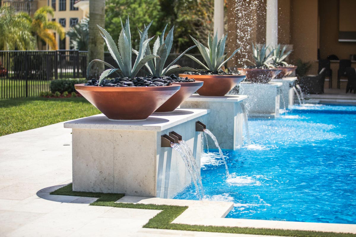 Elegant poolside with cascading water features and decorative planters in royal palm beach