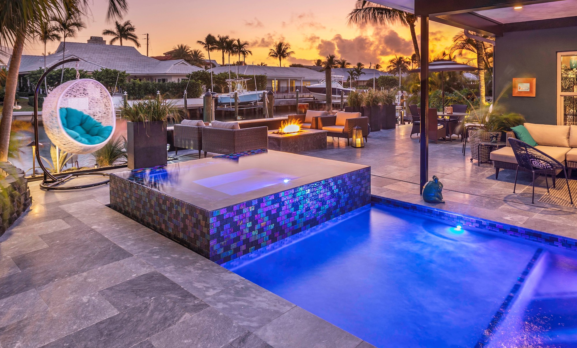 Luxurious patio with pool, fire pit, and seating area at sunset, creating a serene and inviting outdoor space in Port St. Lucie, FL.