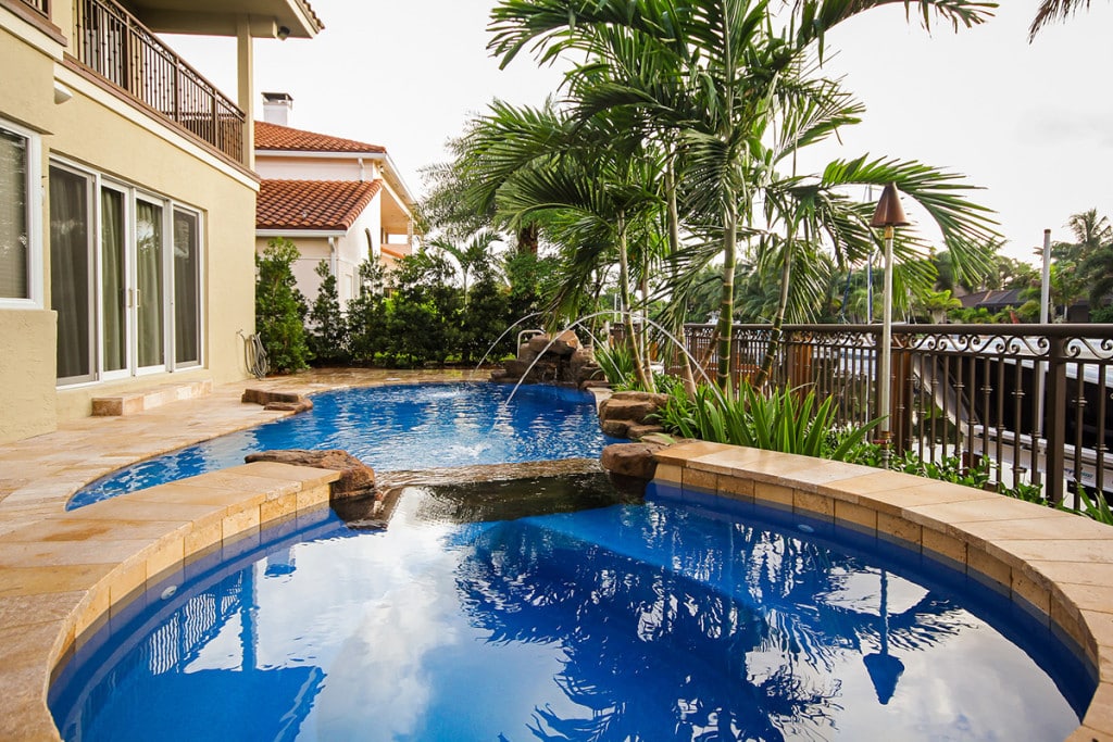 Luxury outdoor pool with tropical landscaping and modern patio design in north palm beach