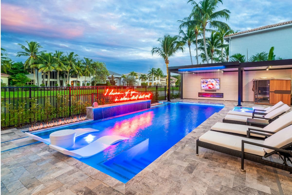 Straight-line pool with neon wall, LED accents, and in-water loungers.