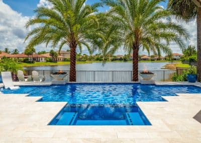geometric straight-line pool with infinity edge spa, fire bowls, and lake view.