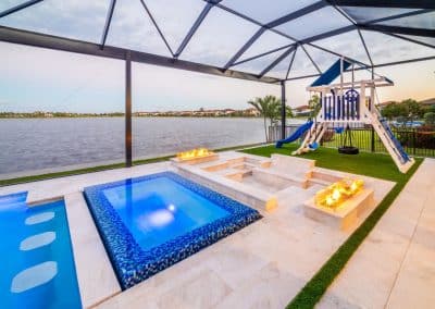 Screened lanai with linear pool, mosaic-tile spa, and recessed fire lounge seating.