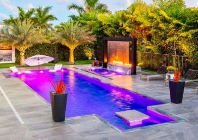Modern geometric pool with water wall, fire feature, and spa.