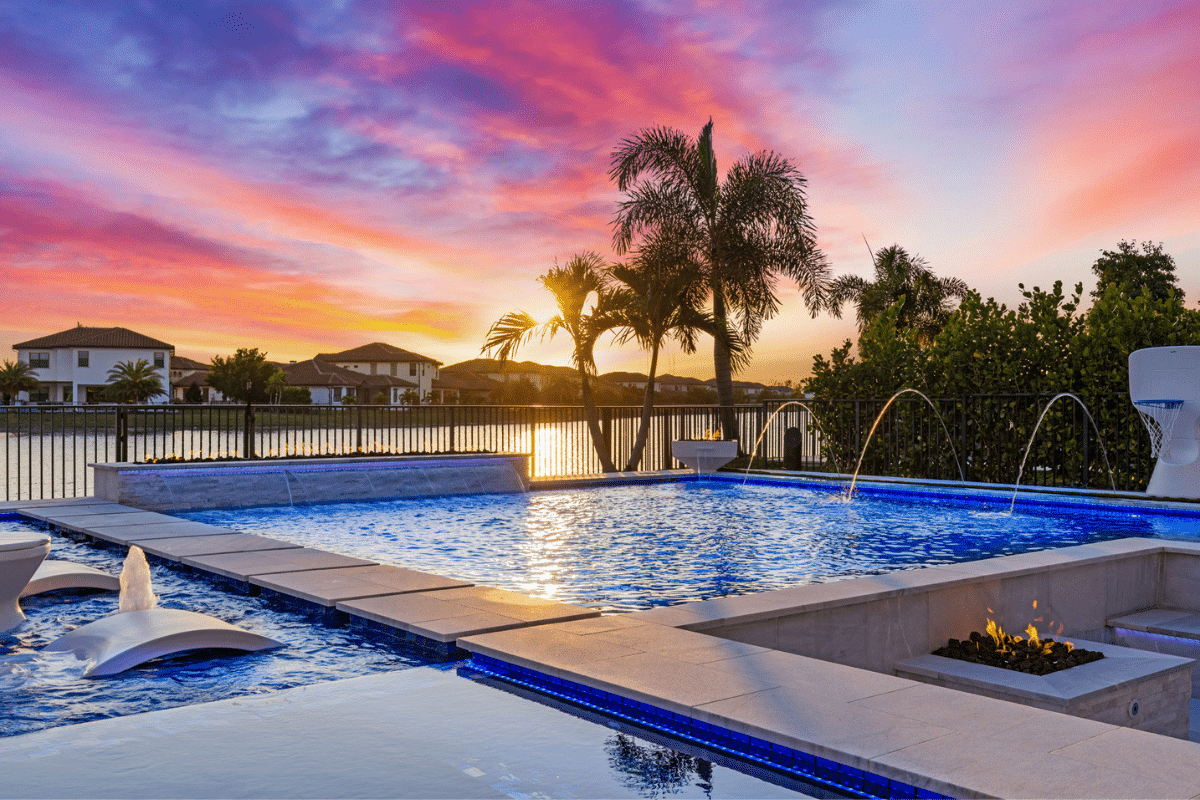 Custom modern geometric pool with a sunken fire pit, LED lighting, and water features in Wellington.