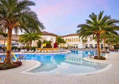 The large, freeform commercial resort pool at Addison Reserve Country Club in Delray Beach, built by Van Kirk Pools, glows at twilight.