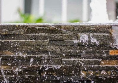 Close-up of stone texture and cascading water at City Furniture Boca Raton.