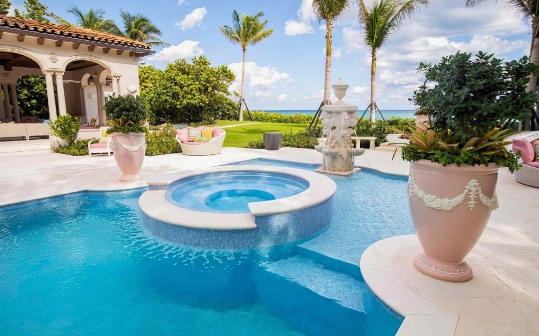 Van Kirk Pools built this oceanfront freeform pool with an attached mosaic tile spa for a luxury Mediterranean estate in Palm Beach, FL.