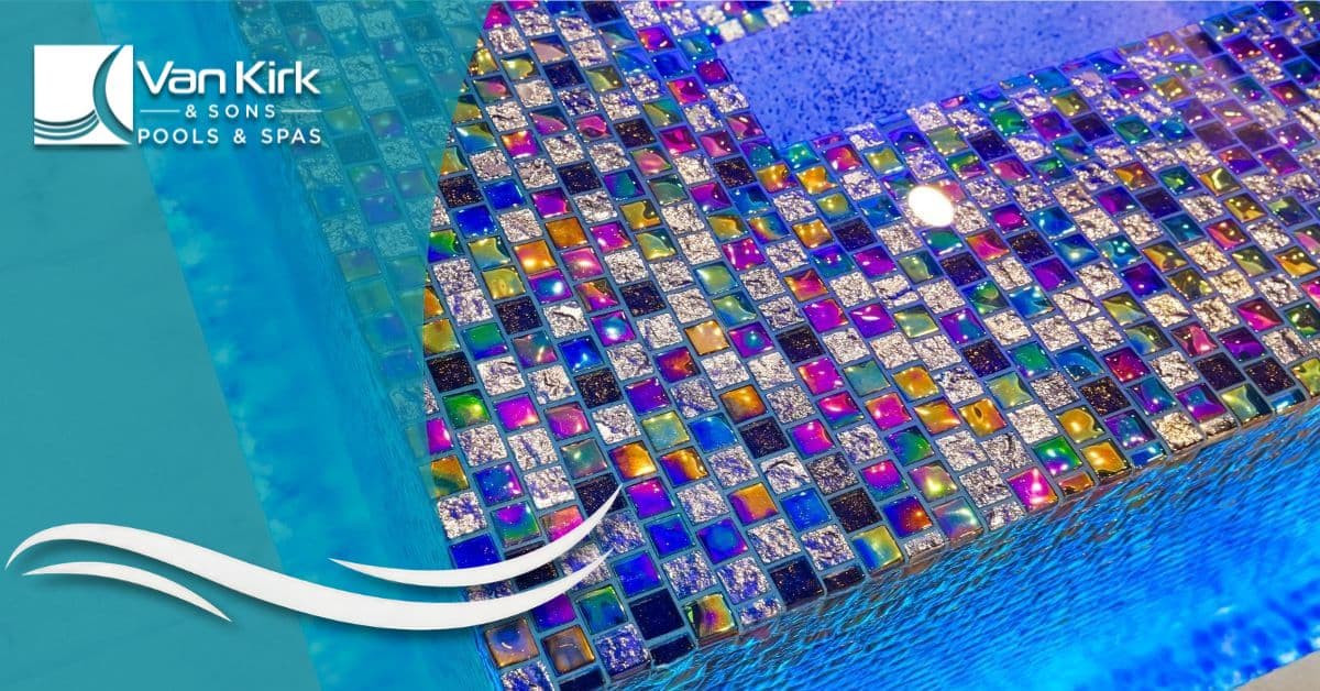 Custom spa with iridescent mosaic pool tiles and LED lighting creating a vibrant modern backyard design.