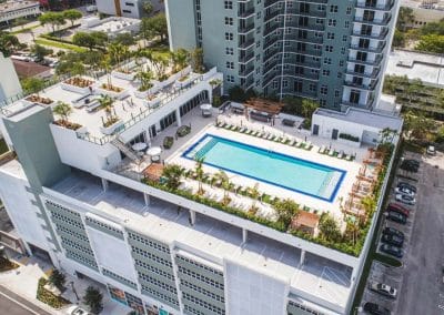 Elevated side view of the high-rise amenity deck in Downtown Fort Lauderdale, focusing on the rectangular pool, modern planters, and surrounding seating.