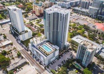 Wide aerial view of the Downtown Fort Lauderdale apartment high-rise, showing the rooftop amenity pool deck built atop the podium, by Van Kirk & Sons.