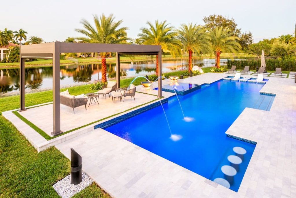 Modern straight-line pool with pergola, laminar jets, and palm landscaping in Florida