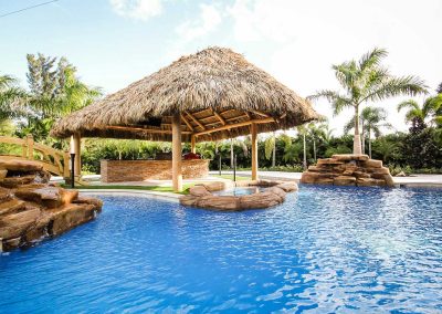 The "Vanilla Ice Project" lagoon pool by Van Kirk Pools, featuring a lazy river, rock spa, custom waterfall, and large tiki hut bar.