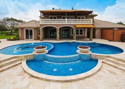 The "Vanilla Ice Project" pool by Van Kirk, featuring a large sun mosaic spa, two fire bowls, a sheer descent waterfall, and a travertine patio.