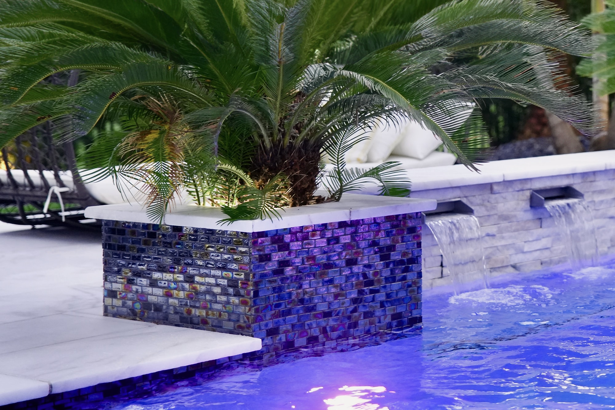 Gradient blue mosaic tiles next to a clear pool by Van Kirk & Sons Pools & Spas.