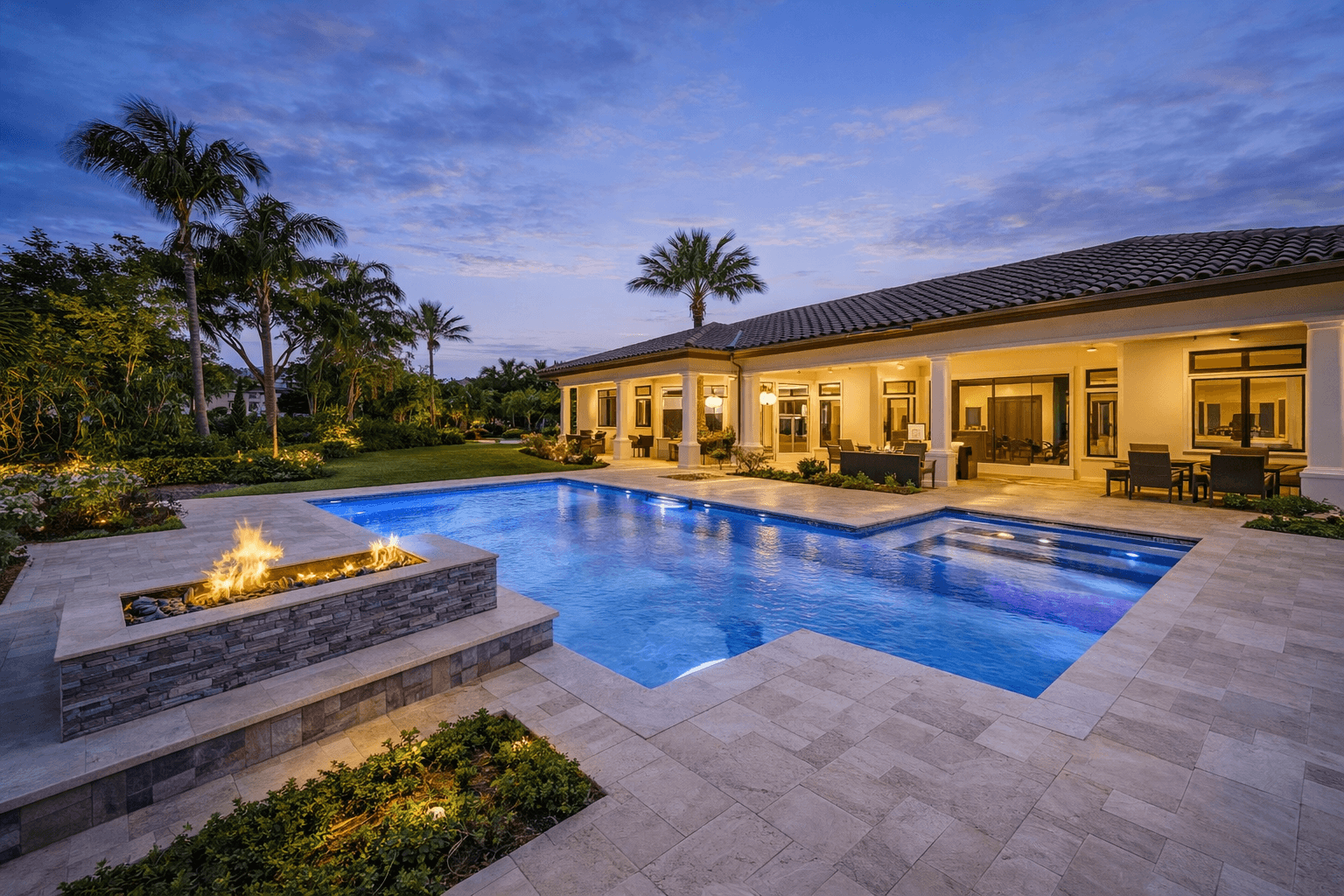 Tropical pool and spa area with palm trees and rock waterfall, designed by Van Kirk & Sons Pools & Spas.