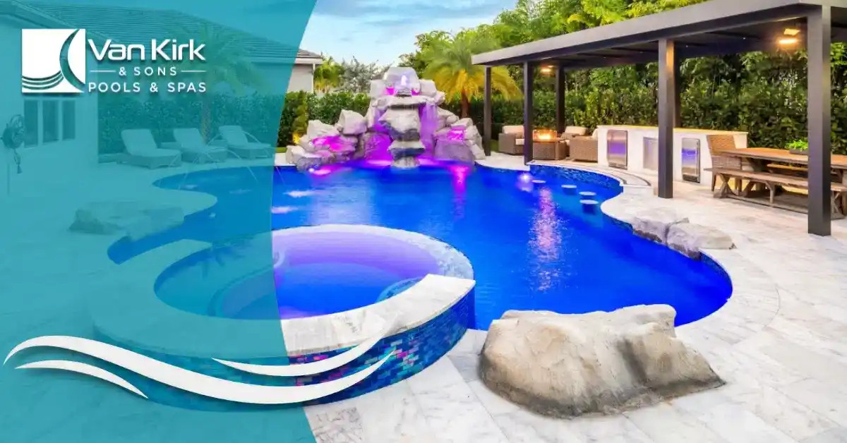 Outdoor pool area with a curved blue pool, rock waterfall, deck, and shaded seating; branding for Van Kirk & Sons Pools & Spas.